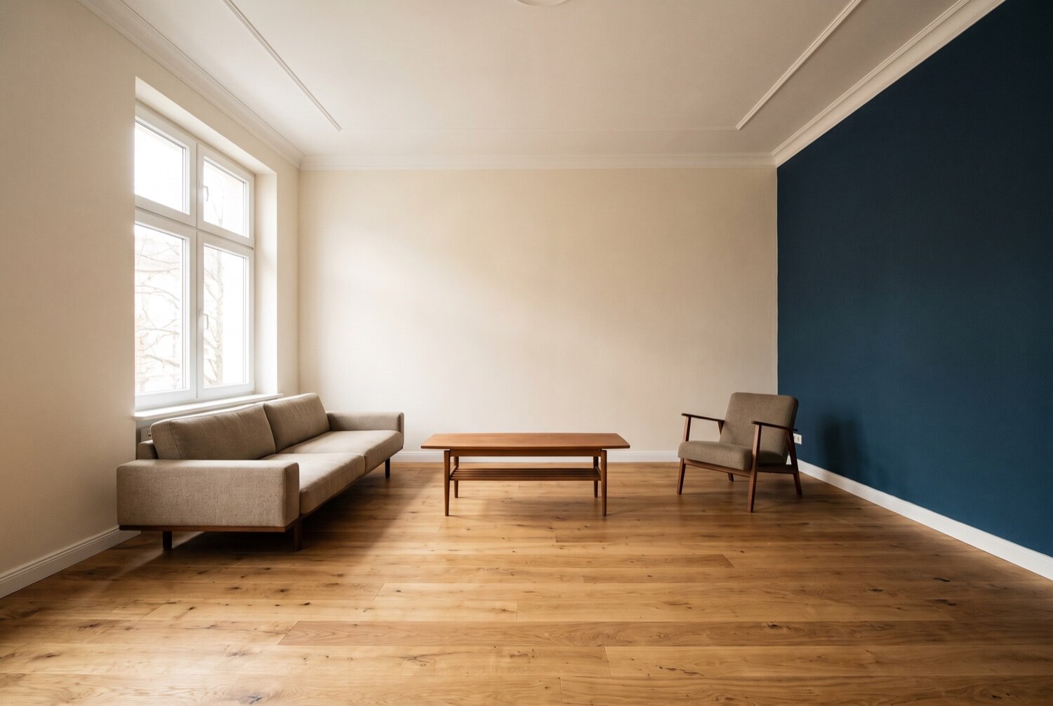 Nachher: frisch renoviertes Wohnzimmer mit weißen Wänden und dunkelblauer Akzentwand